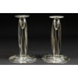 Archibald Knox, pair of Tudric pewter candlesticks, the fin form supports on circular domed bases