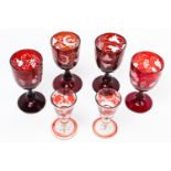 Four Bohemian ruby flash wine glasses, cut through to clear with fruiting vines; and two liqueur