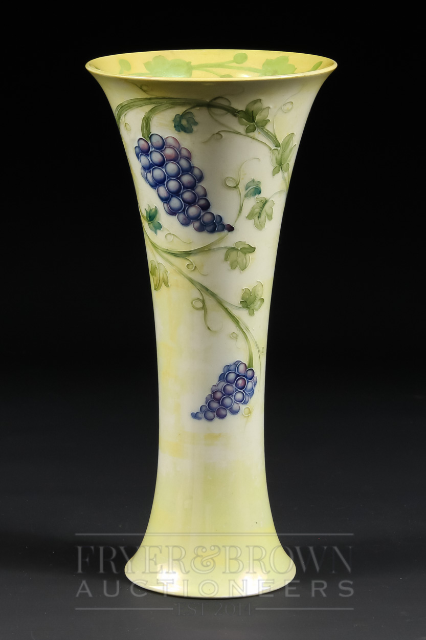 A rare Moorcroft lustre vase of trumpet form, the pale yellow lustre ground decorated with grapes