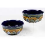 A pair of Royal Doulton stoneware bowls for Claudius Ash & Sons Limited, London, decorated with