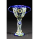 A William Moorcroft MacIntyre two-handled chalice, tubelined with a design of multi-headed flowers
