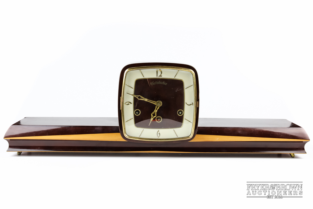 An Art Deco mantle clock , 66 cm long, shelf to either side of square face clock, Westminster