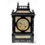 An Aesthetic Movement clock, ebonised wood, the dial and decorative panels in Longwy pottery