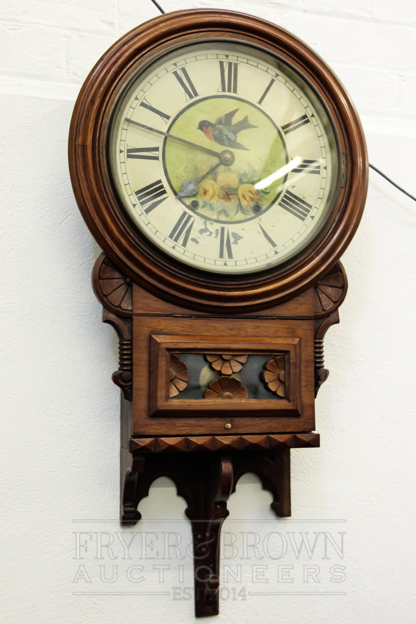 An American walnut wall clock, the circular metal dial painted with a swift and roses above a