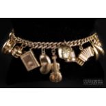 A 9 carat gold charm bracelet, c1950, the graduated curbed link chain mounted with 24 various gold