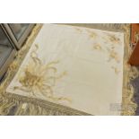 A Chinese ivory silk shawl, with couched gold thread embroidery of a phoenix in flight, long