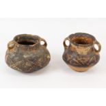 Two Chinese Neolithic redware pottery urns, each of squat globular form, with loop handles to the
