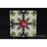 A Qajar tile, brightly glaze with a Damascus rose and four rose buds on crossed band, 19.5cm square