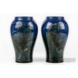 A pair of C.H. Brannam Sgraffito fish vases of baluster form, the glaze graduated from blue to sea