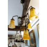 An Art Deco/Art Nouveau brass light fitting, the central suspended shade surmounted by a trefoil