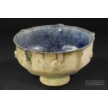 A Iranian pottery bowl, with moulded ribbed and barbed rim, applied with florets to exterior, the