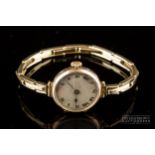 A vintage 9ct gold ladies wrist watch, c1920, the silvered dial with black and red Roman numerals,