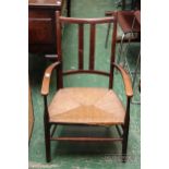 An Arts & Crafts mahogany arm chair with rush seat