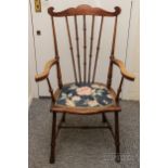 An elm carver chair, spindle back, carved arm rests and upholstered seat