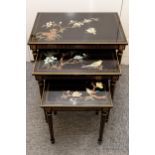 A nest of three Oriental style black lacquer tables decorated with flowers and birds, with ornate