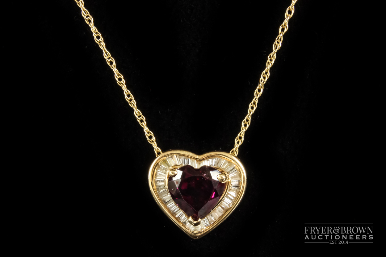 A heart shaped almandine garnet and calibre baguette diamond pendant, the heart shaped garnet of