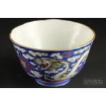 A small Chinese porcelain bowl, enamelled with scaly dragons on a blue ground cloud background,