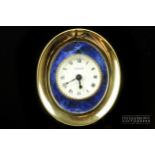 Cartier, a vintage gilt bronze and enamel alarm clock, c1965, the oval shaped gilded bronze frame