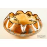 A Carl Goldberg silver overlay amber glass bowl, with scalloped inverted rim with silvered floral