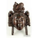 An unusual Chinese carved hardwood wall mask of a lady, glass and ebony inlaid eyes, with
