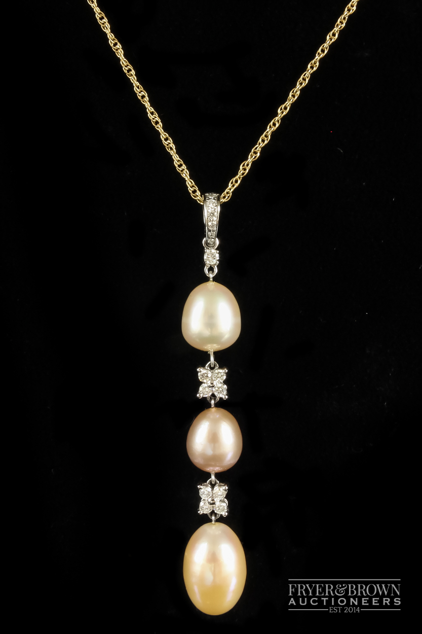 An 18ct gold, diamond and coloured pearl pendant, set with three slightly graduated pearls of