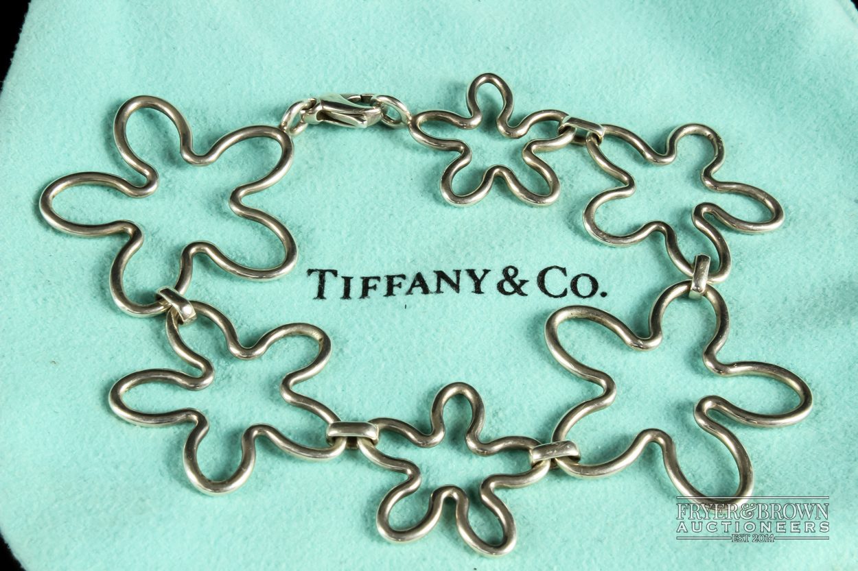 Tiffany & Co. - a silver bracelet, composed of six graduated irregular cinquefoil motifs, signed T &
