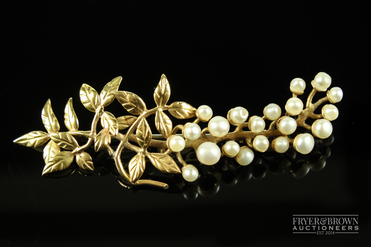 A yellow metal and split pearl brooch, formed as a stylised leafy 'flowering' branch, marked to