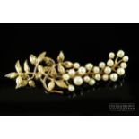 A yellow metal and split pearl brooch, formed as a stylised leafy 'flowering' branch, marked to