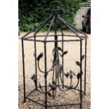 A large wrought iron hexagonal garden candle torchere, of bird cage form with leaf adorned armature,