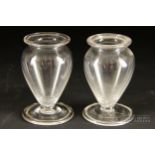 A pair of English colourless glass posey vases, c1830, ovoid on spreading foot, 9cm high (2)