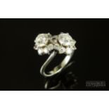 A fine two stone diamond cross over cluster ring, the diamond clusters set to each centre with a