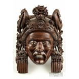 A Chinese carved hardwood wall mask of an elderly lady, with bone and ivory inset eyes and teeth,