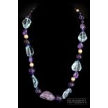 A blue topaz and amethyst bead necklace, the graduated necklace set with 29 polished amethyst and