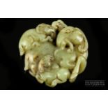 A Chinese mutton fat jade carving of a goat and two young, the mixed mottled celadon jade carved