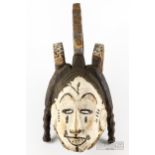 An African ceremonial sprit or Mwo mask, the carved wood painted in black and white, modelled as a
