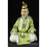 A Japanese Kutani enamelled and gilt figure of a scholar, c1900, the seated figure with green