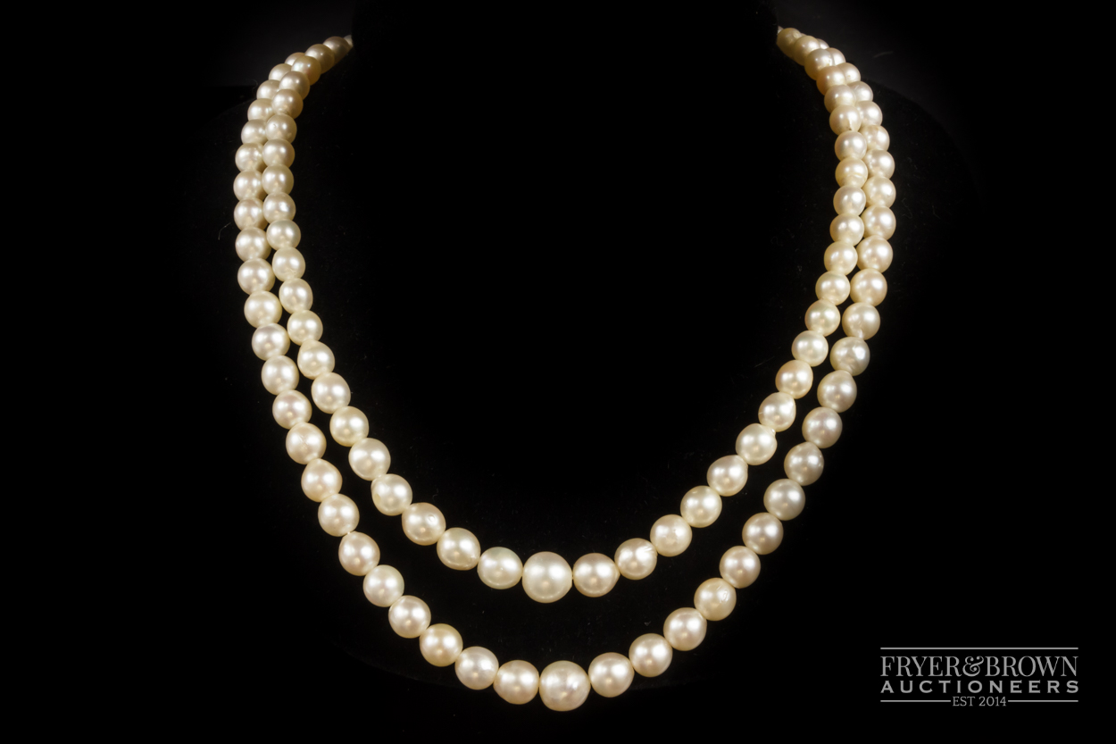 A two row cultured pearl necklace, with tourmaline and diamond clasp, comprising 62 and 66 graduated