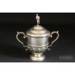 A silver trophy cup & cover, of typical form with scroll handles and gadrooned base, the cover