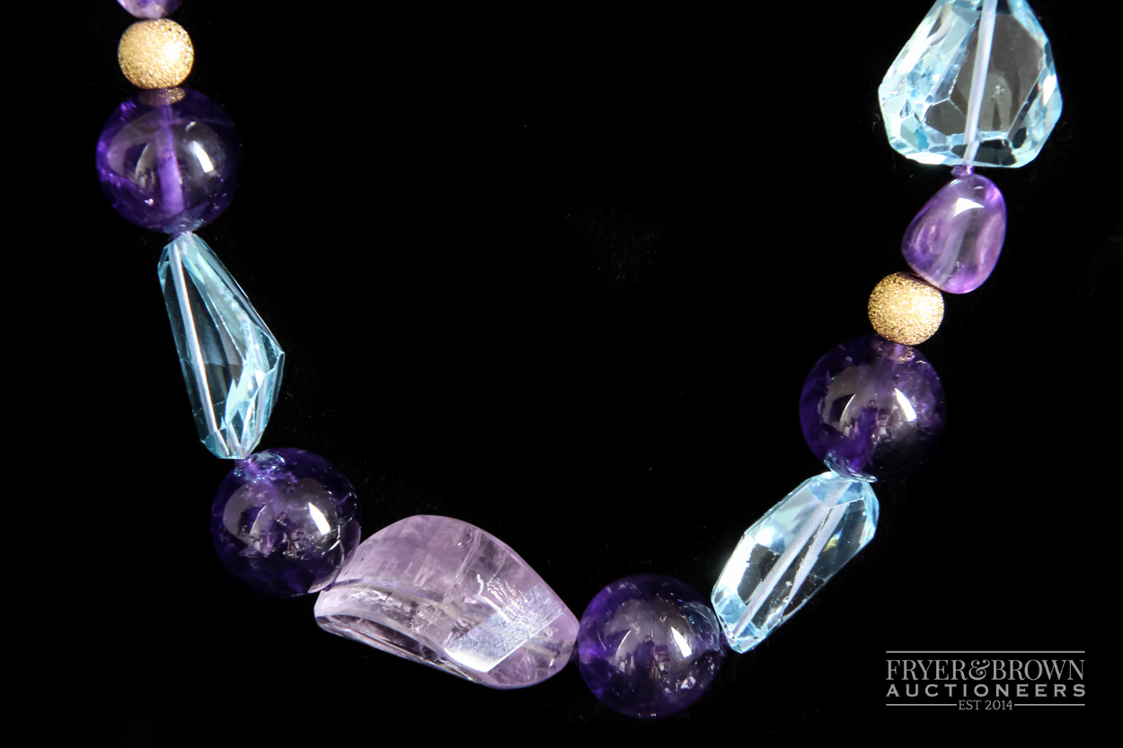 A blue topaz and amethyst bead necklace, the graduated necklace set with 29 polished amethyst and - Image 2 of 3