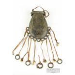 An African bronze pouch, hung with leather straps terminating in rings and shells, probably Nigerian