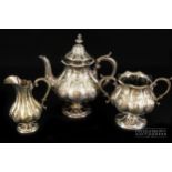 A silver plated three-piece tea service, of melon form, decorated with fruit medallions and