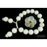 A white jade bead bracelet, composed of 18 uniform sized beads; and a whitish jade gem set brooch,
