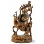 A Chinese wood carving of Shou Lao riding a deer, his right hand holding a staff suspending a double