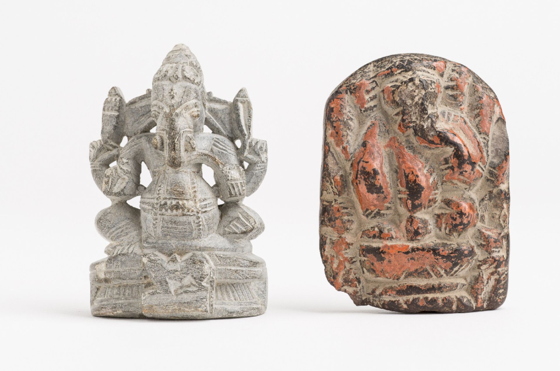 TWO STATUETTES OF GANESHA  Stone. India, 19th and 20th cent.  One stele bears a red colour and shows