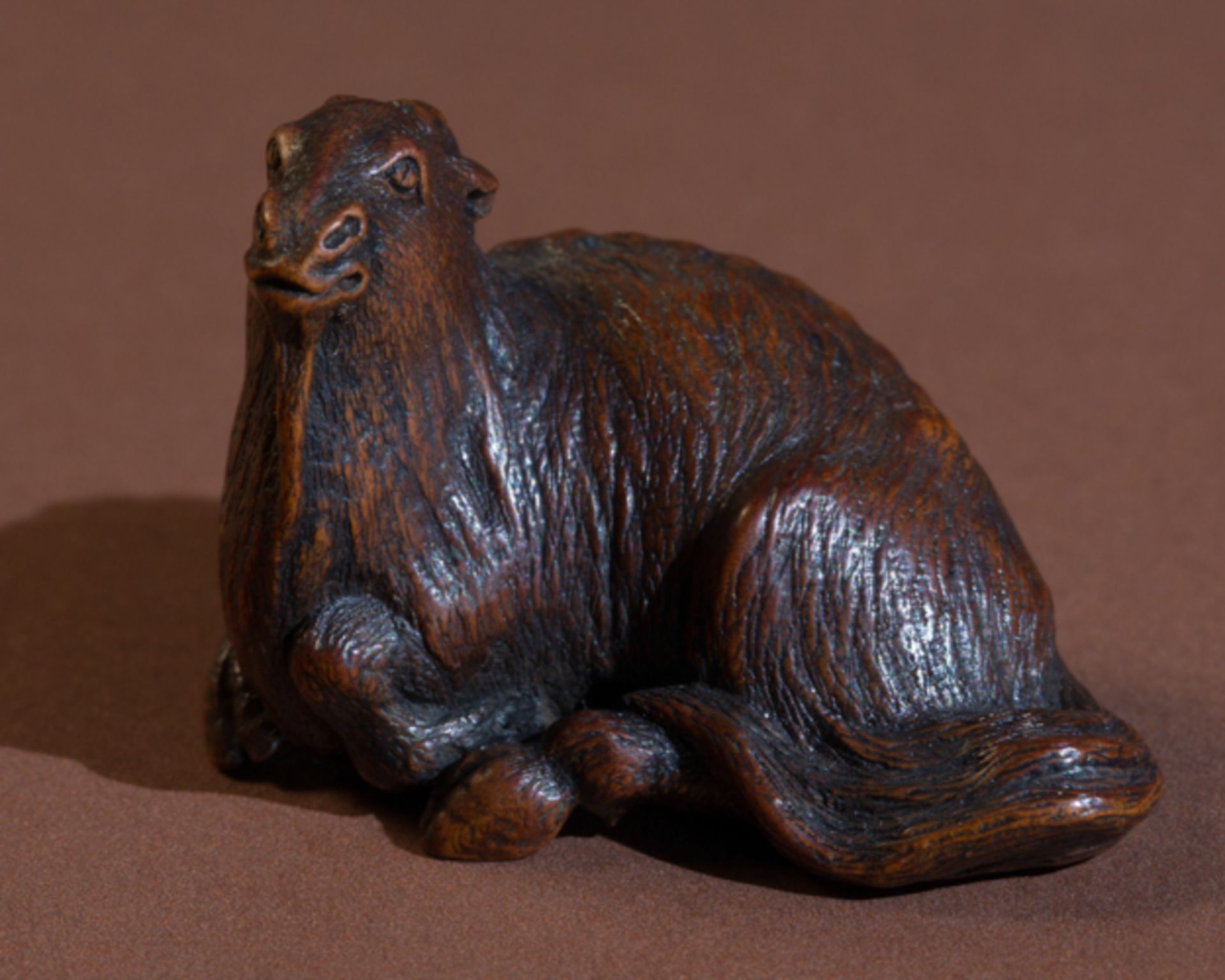 MASAYASU: RECUMBENT BILLY GOAT  Netsuke, wood. Japan, 19th cent.  Very good naturalistic work,