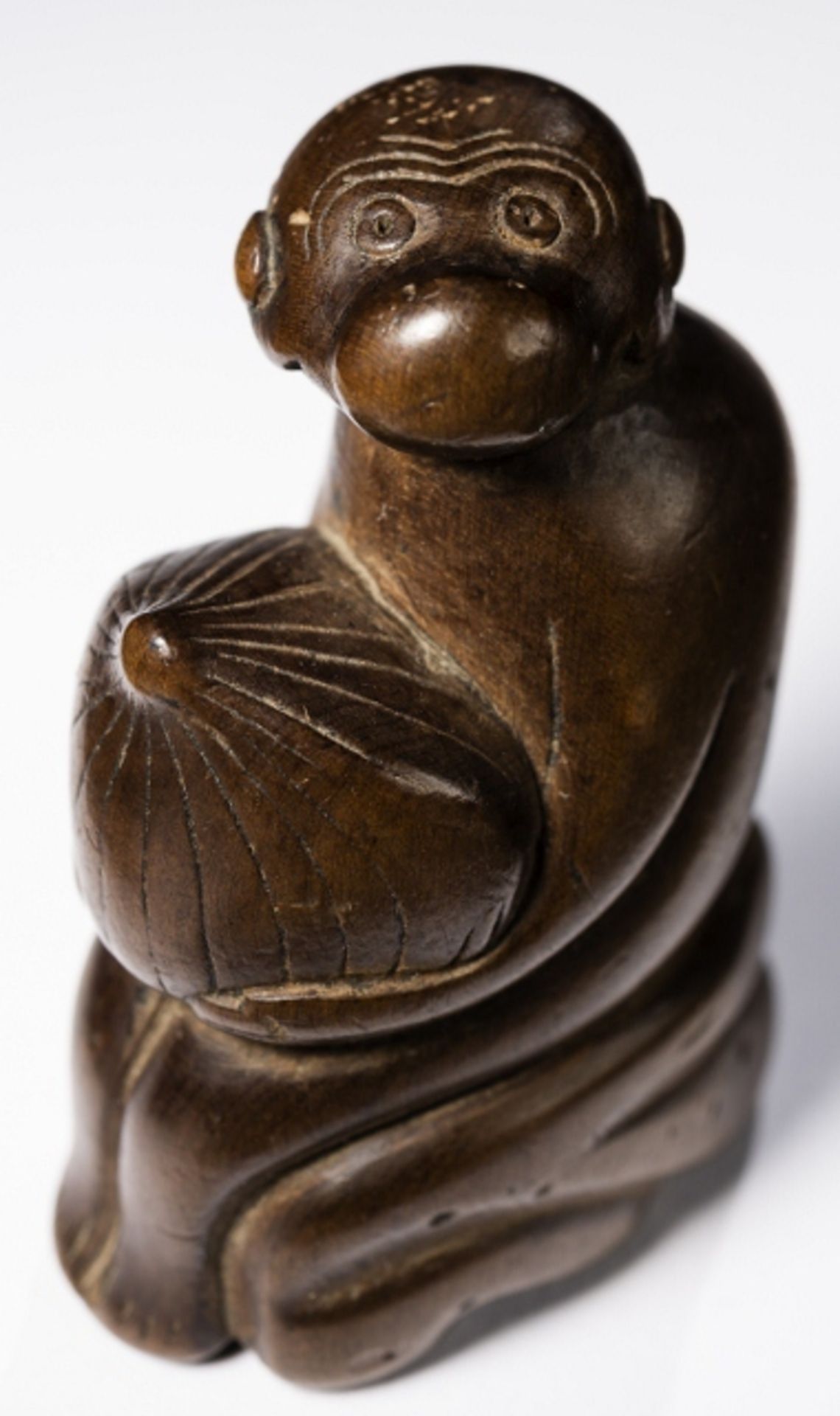 MONKEY WITH FRUIT    Netsuke, wood, Japan, early 19th century. HEIGHT 5,55 CM   The monkey sits on a