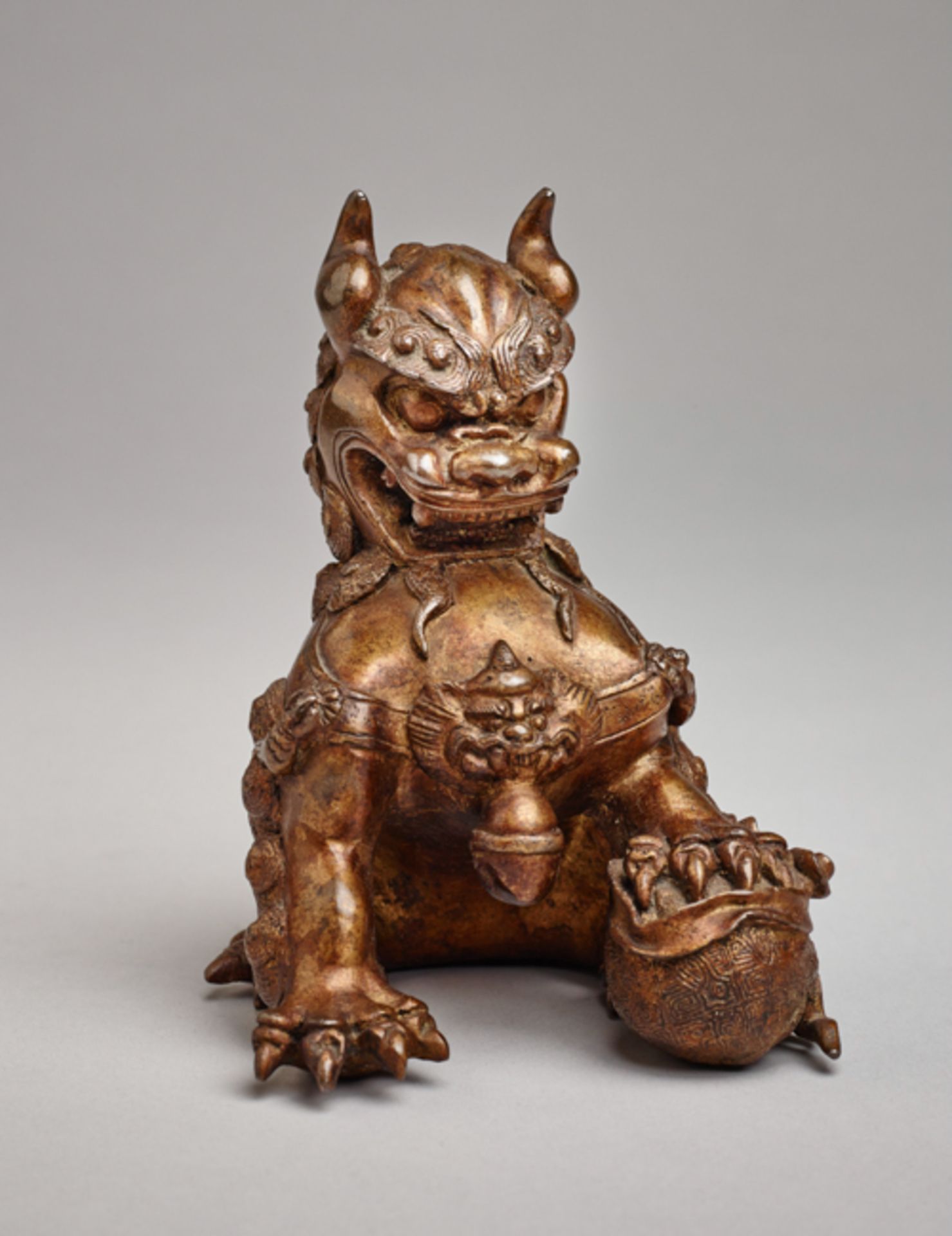 PALACE LION WITH BALL  Bronze with lacquer gilding. China, late Qing dynasty, approx. 19th cent.