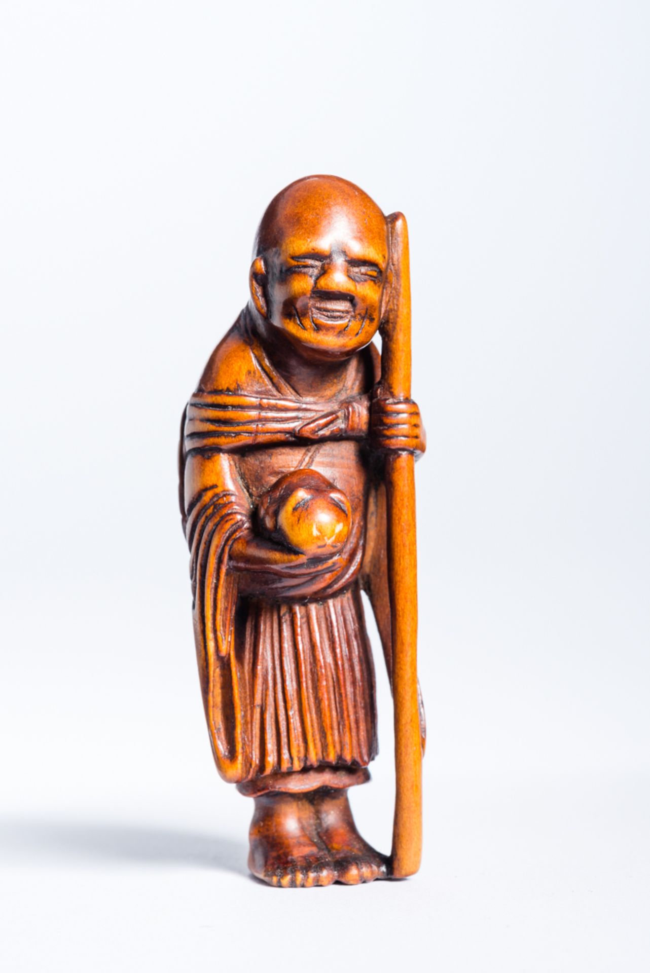 MASAKUNI: SAIGYO HOSHI MIT KÄTZCHENNetsuke. Holz. Japan, 19. Jh.Saigyo Hoshi, dessen „bürgerlicher“
