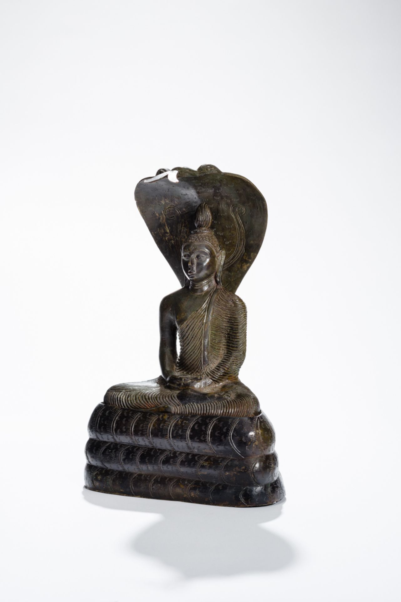 BUDDHA MUCHALINDABronze. Ceylon, Kandyan, ca. 19. Jh.Buddha sitzt in Paryankasana auf der dreifach