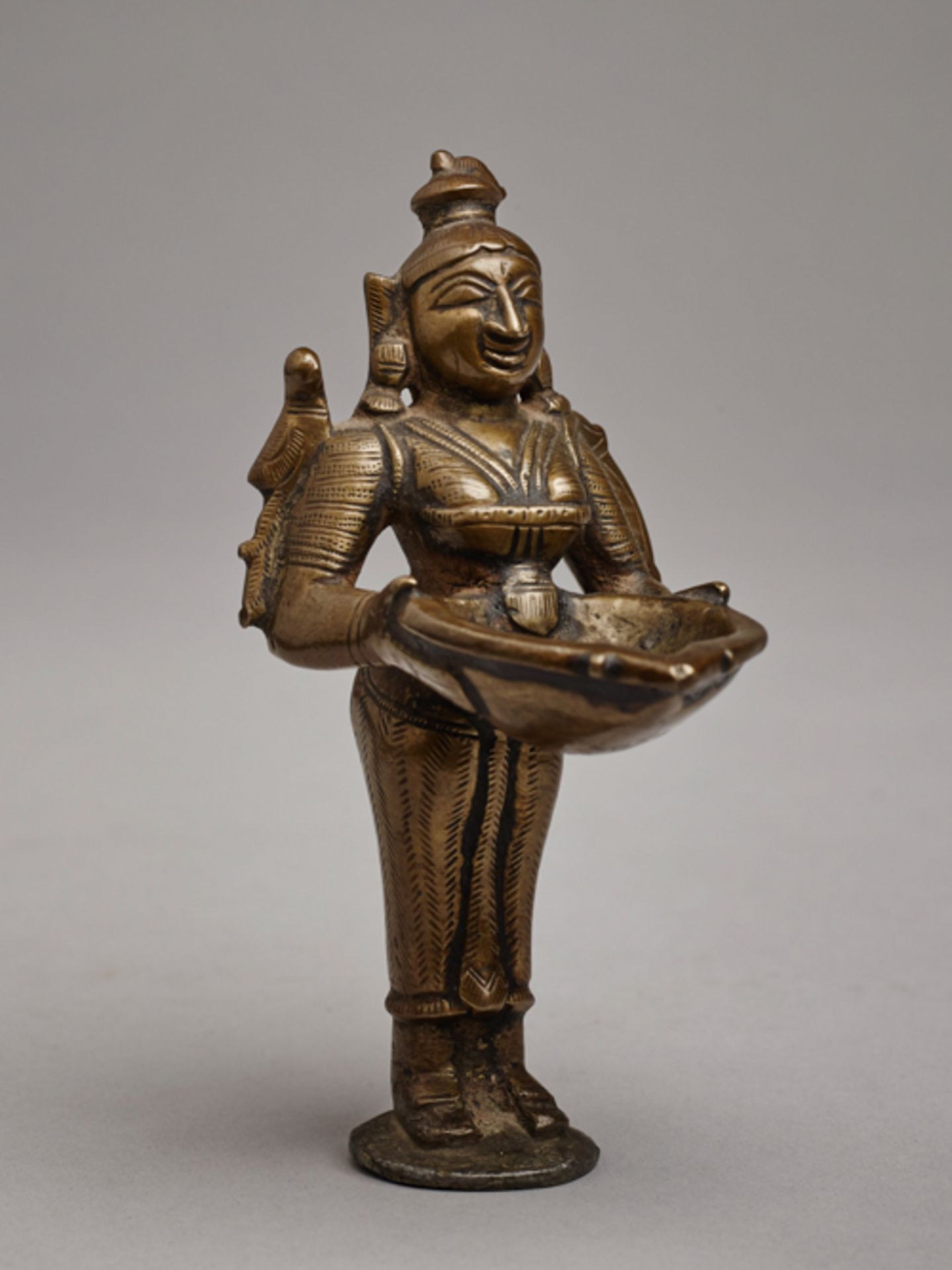 KLEINE ÖLLAMPE IN FORM LAKSHMI
INDIEN, 19. Jh. Messingbronze in schöner Gußqualität. Provenienz: